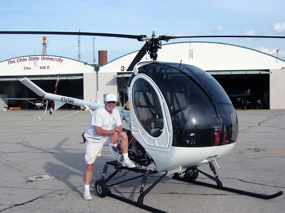 Charlie Duchek on ramp with Schweizer 300 helicopter