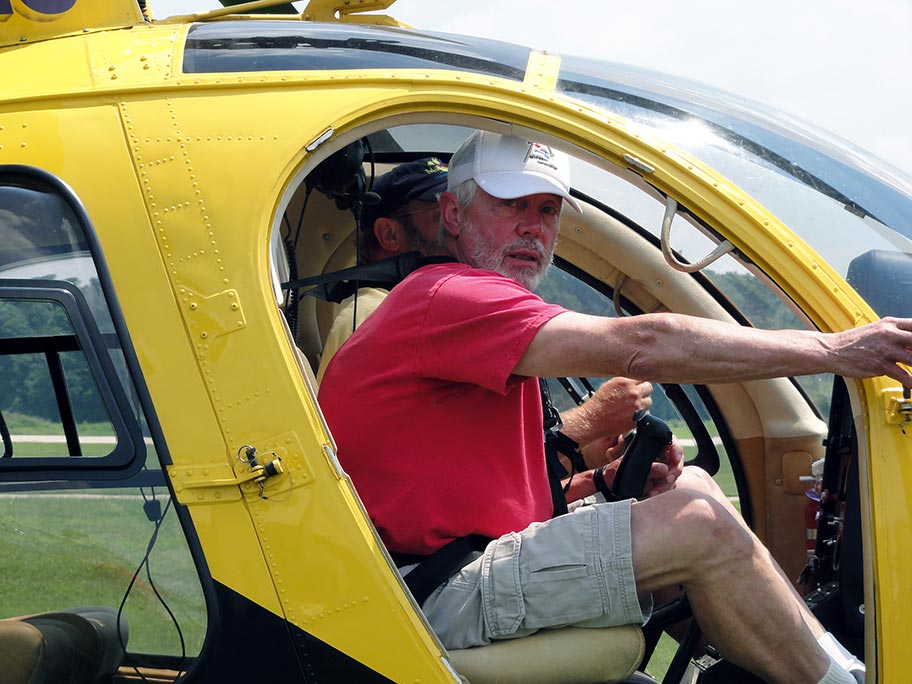 Charlie Duchek in cockpit of Schweizer 300 helicopter